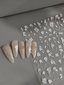 Detailansicht der 3D-Prägung weißer Blumen-Nagelaufkleber mit eleganten Perlenakzenten