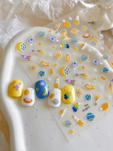 Detail of space-themed nail stickers with rockets, planets, and cartoon astronaut cats