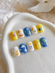 Close-up of space theme nail stickers with cute rocket and astronaut cat designs