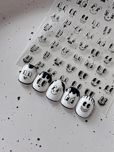 Macro shot of retro cartoon nail stickers with vintage rubber hose style facial expressions