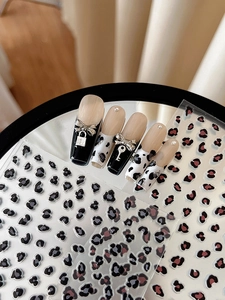 Vue détaillée d'autocollants pour ongles léopard avec nœuds métalliques sur miroir
