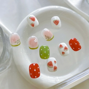 Détail d'autocollants pour ongles motif fleurs d'été et pastèque sur un plat blanc