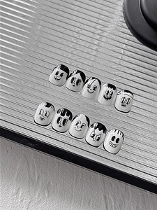 Macro shot of black and white cartoon expression nail art stickers on fluted glass
