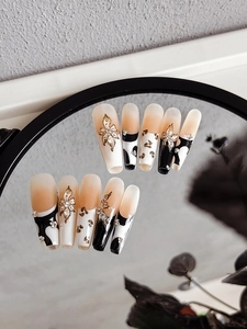 Detailed mirror view of long coffin press-on nails with 3D gold flowers and cow print art