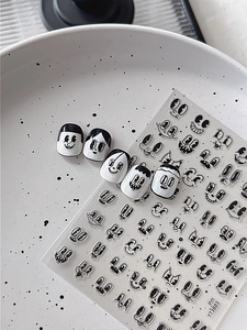 Detailed close-up of retro cartoon facial expression nail stickers on a ceramic tray