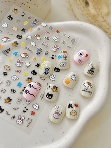 Detail of cute cartoon nail art stickers with rabbits and bows on manicure tips