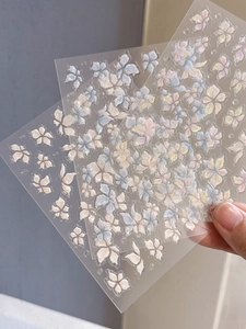 Close-up of three 3D lily flower nail stickers with iridescent jelly shell finish