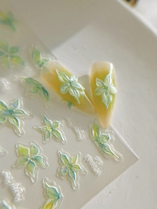 Détail macro de stickers ongles relief 3D avec fleurs irisées et fini nacre