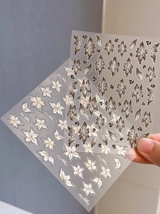 Detail of 3D brown and beige flower nail art stickers with vintage floral patterns