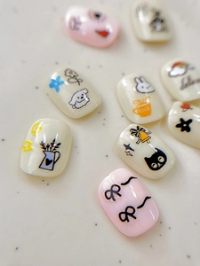 Close-up of cute cartoon nail stickers featuring rabbits, cats, and blue flowers