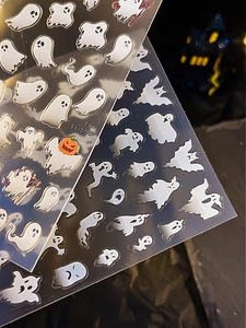 Gros plan d'autocollants nail art Halloween avec fantômes argentés et motifs citrouilles