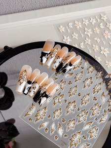 Detail of 3D embossed flower nail stickers with gold edges and leopard print press-on nails