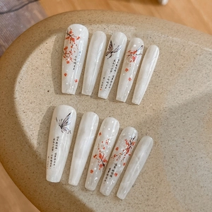 Detail of long coffin press-on nails featuring red plum blossoms and ink butterfly art