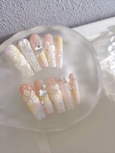 Detailed view of handmade pink gradient long coffin nails with 3D floral and bow accents