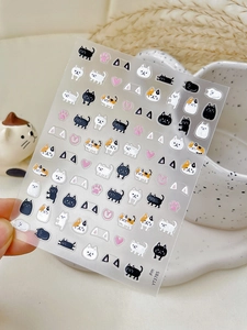 Gros plan d'autocollants nail art chat avec chats noirs blancs et pattes roses