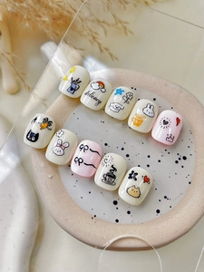 Close-up of Japanese-style rabbit and cat press-on nails on a ceramic plate