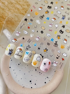 Detail of cute cartoon nail stickers featuring rabbits and cats on soft pink nail tips