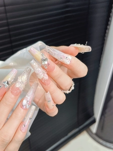 Detail of extra-long pink gradient press-on nails with 3D carved flowers and rhinestones