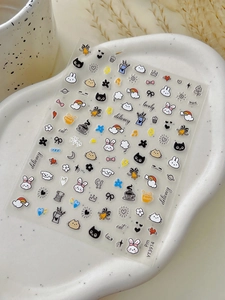 Close-up of cute cartoon nail art stickers with cats and rabbits on a ceramic tray