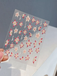 Détail macro des stickers nail art YT3946 avec motifs de lys rouges et lettrage