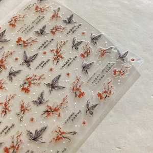 Macro view of Chinese plum blossom and butterfly nail stickers with gold foil details