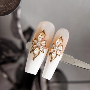 Long coffin press-on nails with pink gradient and gold embossed 3D floral accents