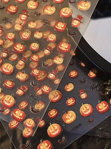 Macro shot of 3D embossed Halloween nail stickers with orange pumpkins and bats