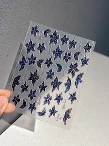 Détail de stickers à ongles fleurs en gelée bleue et papillons avec finition pailletée