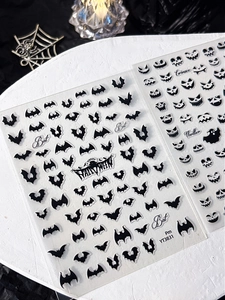 Macro view of Halloween nail stickers featuring bat silhouettes and pumpkin face patterns