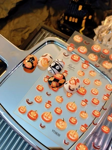 Macro detail of Halloween nail stickers with evil pumpkin and bat patterns YT3830
