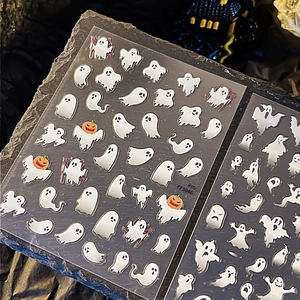 Autocollants d'ongles fantômes d'Halloween avec citrouilles sur fond de roche sombre