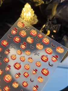 Detail of Halloween nail stickers featuring evil jack-o'-lanterns and bats for nail art