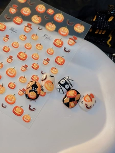 Halloween nail stickers with spooky pumpkin patterns and ghost motifs shown on fake nails