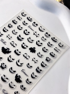 Detail of 3D embossed Halloween nail stickers with black ghost and spooky face patterns