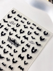 Detail of 3D embossed Halloween nail stickers with black bats and festive lettering