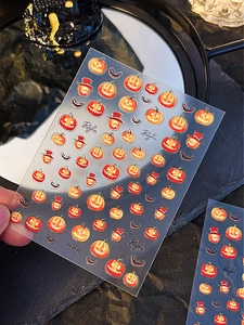 Detail showing Halloween pumpkin and bat nail stickers on a clear backing sheet