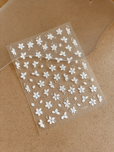 Detailed macro view of 3D embossed white floral nail art stickers with item number YT3854