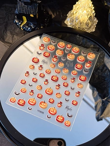 Halloween pumpkin and bat nail stickers displayed on a mirror with spooky festive decor
