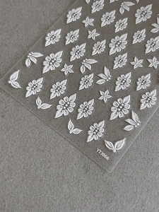 Macro detail of white 5D embossed floral nail stickers showing texture on model YT3866