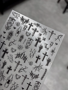 Detail shot of black gothic nail stickers with cross, spider web and coffin motifs