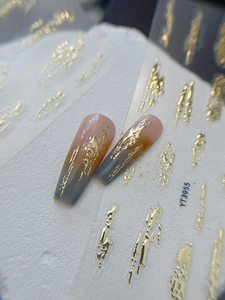 Nahaufnahme von Nagel-Charms YT3955 mit geprägten Goldfolienlinien und Farbverläufen