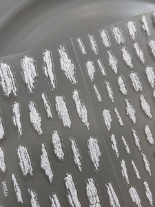 Nahaufnahme weißer 3D-Nagelsticker mit geprägter Pinselstrich-Textur und 3D-Relief-Effekt