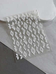 Macro detail of 3D embossed white floral nail art stickers with fine petal textures