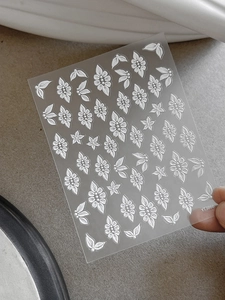 Detailed macro view of 5D embossed white floral nail stickers featuring daisy patterns