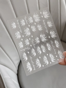 Detailed view of white floral nail art stickers with lotus designs on transparent backing
