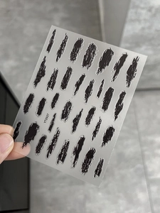 Nahaufnahme von schwarzen Tuschestrich-Nagelstickern mit modernen Texturen, Modell YT3937