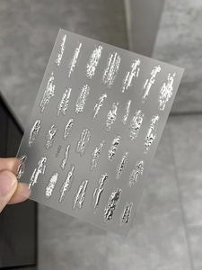Detailansicht der silbernen Metallic-3D-Nagelsticker mit unregelmäßigen flüssigen Formen