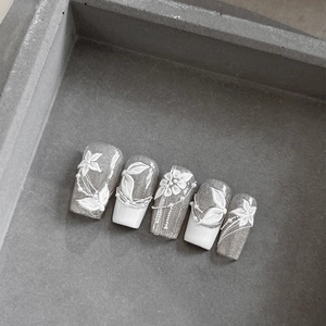 French style press-on nails with embossed white floral patterns and pearl chains