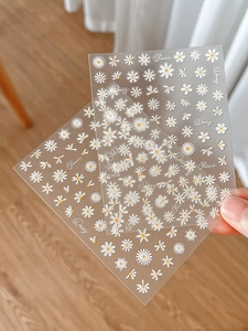 Close-up of 3D embossed daisy nail art stickers with Flower and Daisy text patterns