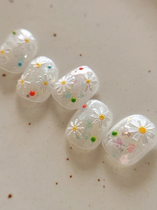 Macro detail of 3D embossed daisy nail art stickers with glitter on jelly base finish